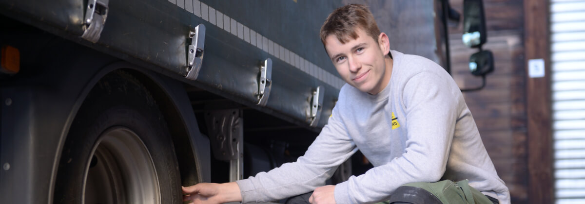 Lastwagen und junger Mitarbeiter